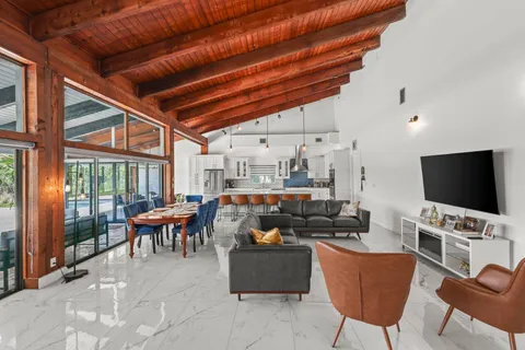a living room with furniture a ceiling fan and a large window