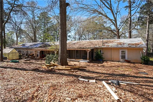a view of a house with a yard and large tree