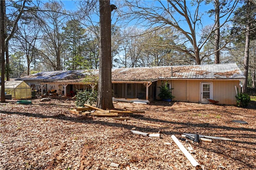 a view of a house with a yard and large tree