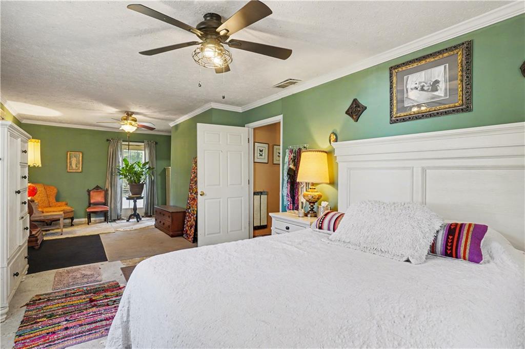 267 Macon Street Monticello, GA 31064 - Photo 18 of 28 a bedroom with a bed and a chandelier