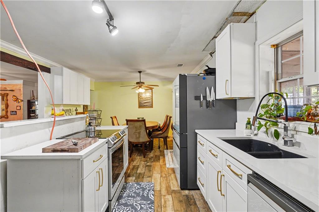 267 Macon Street Monticello, GA 31064 - Photo 7 of 28 a kitchen that has a sink and chairs