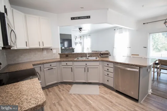 a kitchen with stainless steel appliances white cabinets a stove a microwave and a refrigerator