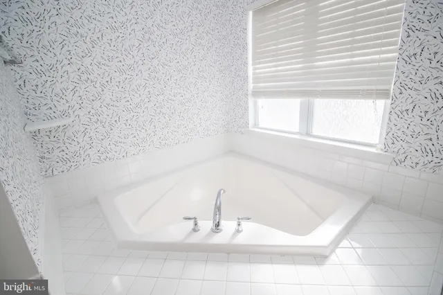 a view of a room with wooden floor and a ceiling fan