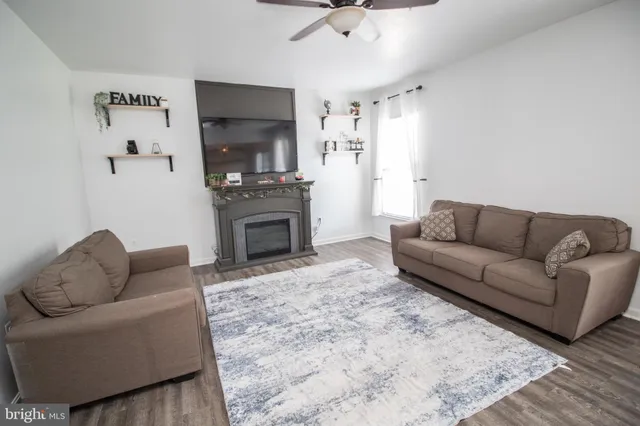 a living room with furniture a flat screen tv and a fireplace