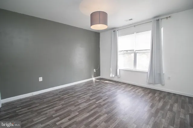a front view of a house with a yard and potted plants