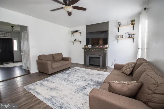 a living room with furniture a flat screen tv and a fireplace