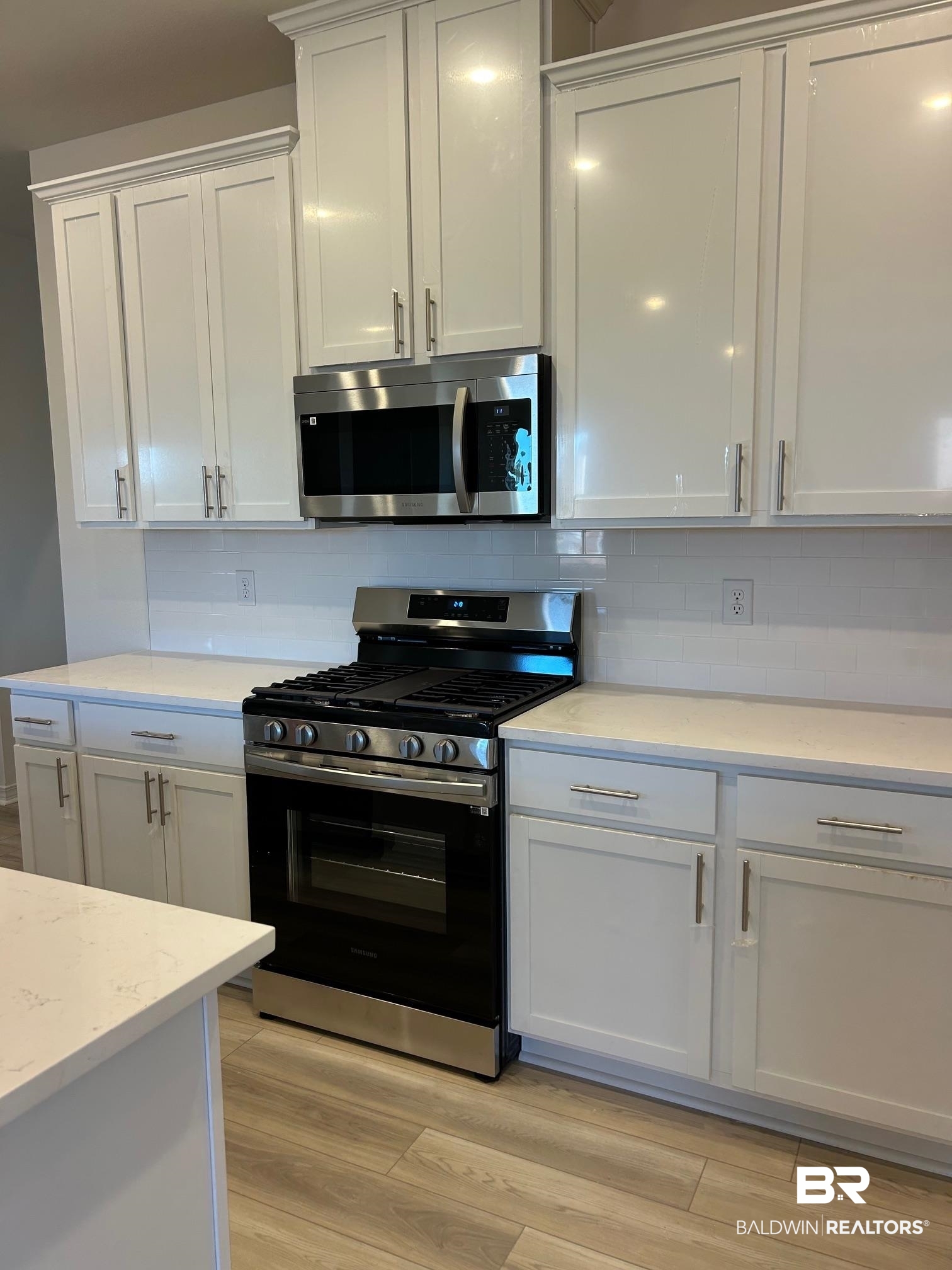 18127 Kent Circle Foley, AL 36535 - Photo 3 of 8 Kitchen with stainless steel appliances, white cabinetry, and decorative backsplash
