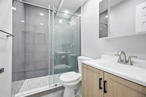 a bathroom with a shower a toilet and a sink