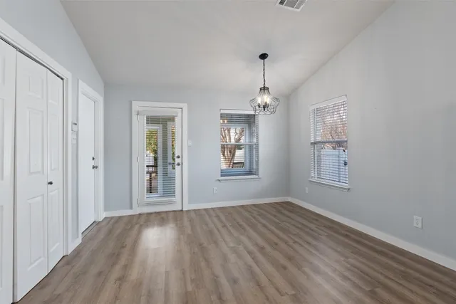 a view of an empty room with wooden floor