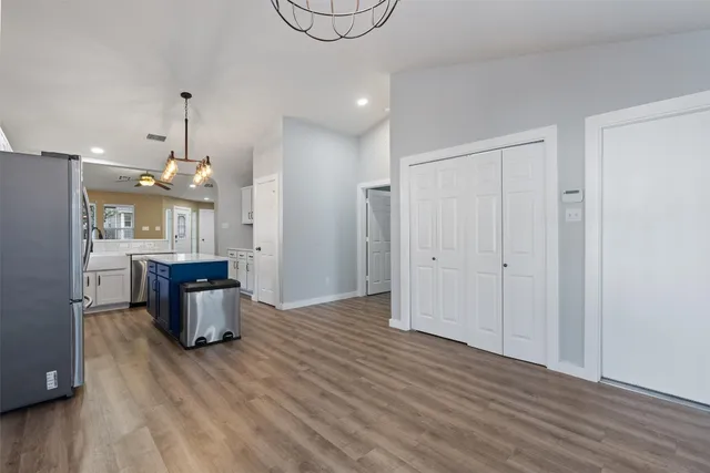 an empty room with wooden floor and fan