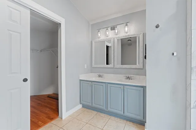 a view of an empty room and chandelier fan