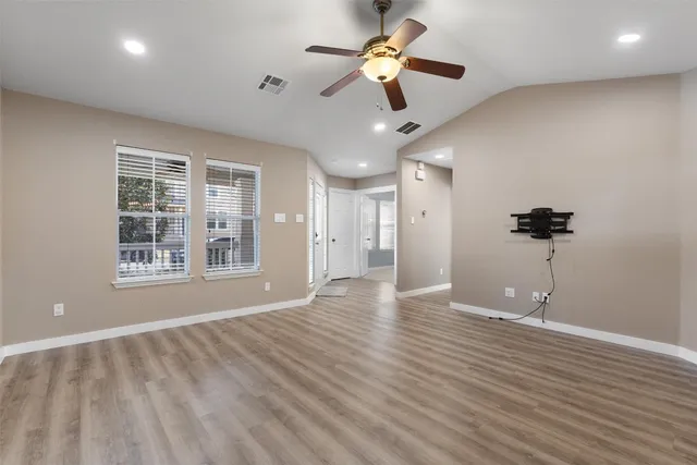 a kitchen with stainless steel appliances granite countertop a refrigerator a stove top oven a sink dishwasher and a refrigerator with wooden floor