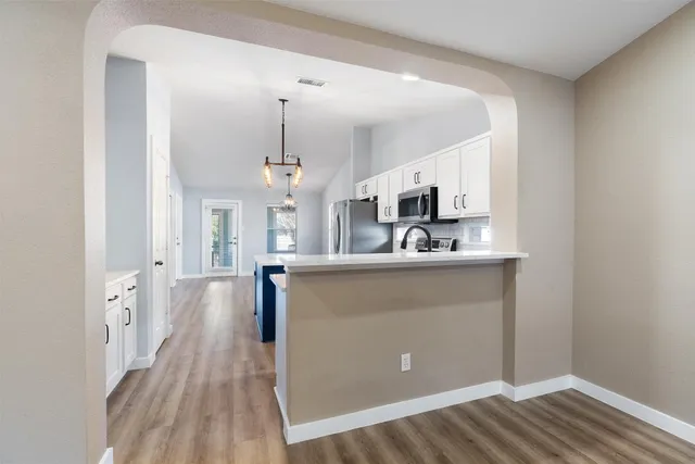 a kitchen with granite countertop a sink stainless steel appliances and cabinets