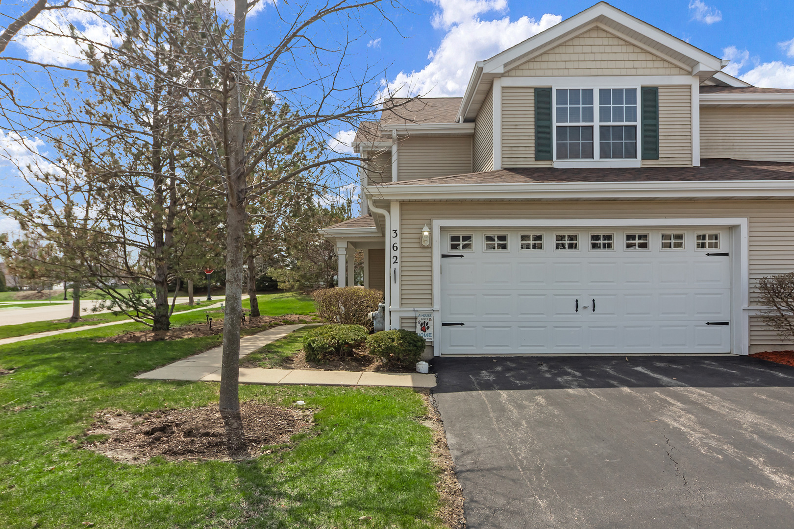 a front view of a house with a yard and trees