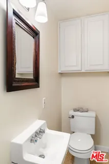 a bathroom with a toilet a sink and mirror