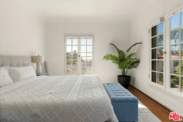 a bedroom with a large bed and a potted plant