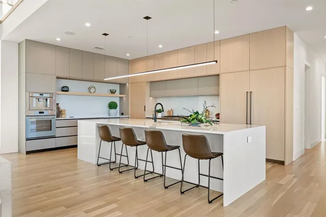 a kitchen with kitchen island stainless steel appliances a dining table and chairs