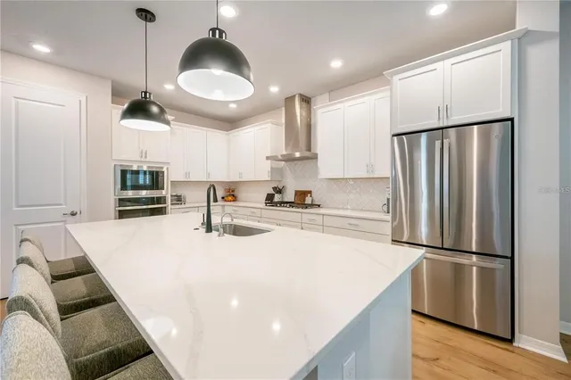 a kitchen with stainless steel appliances a refrigerator and a stove