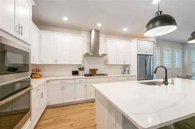 a kitchen with kitchen island a sink stainless steel appliances and cabinets
