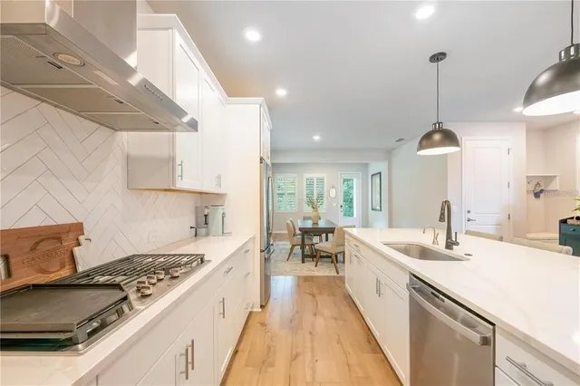 a kitchen with kitchen island a sink stove and wooden floor