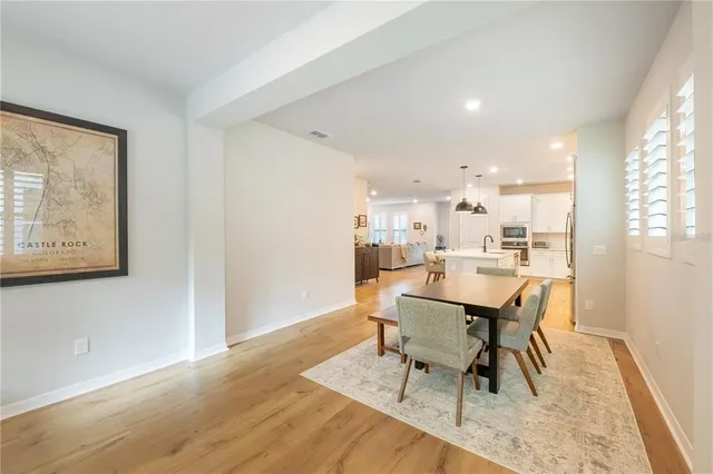 a dining room with wooden floor and a window