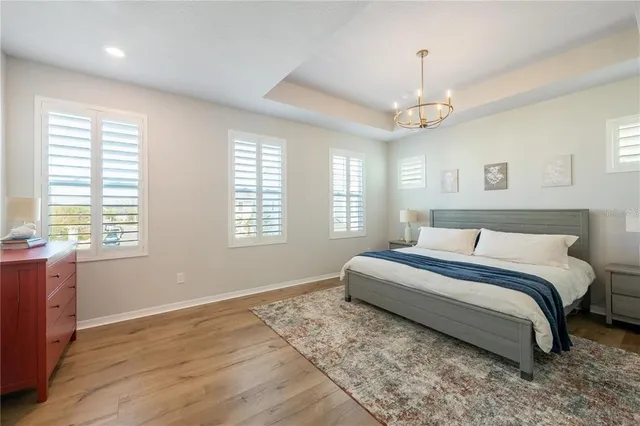 a spacious bedroom with a large bed and a chandelier