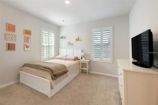 a spacious bedroom with a bed and a flat screen tv