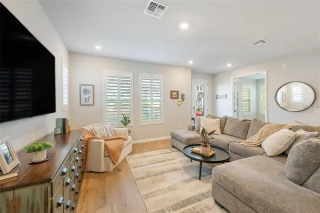 a living room with furniture potted plant and a flat screen tv