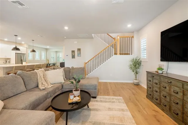 a living room with furniture a flat screen tv and a dining table