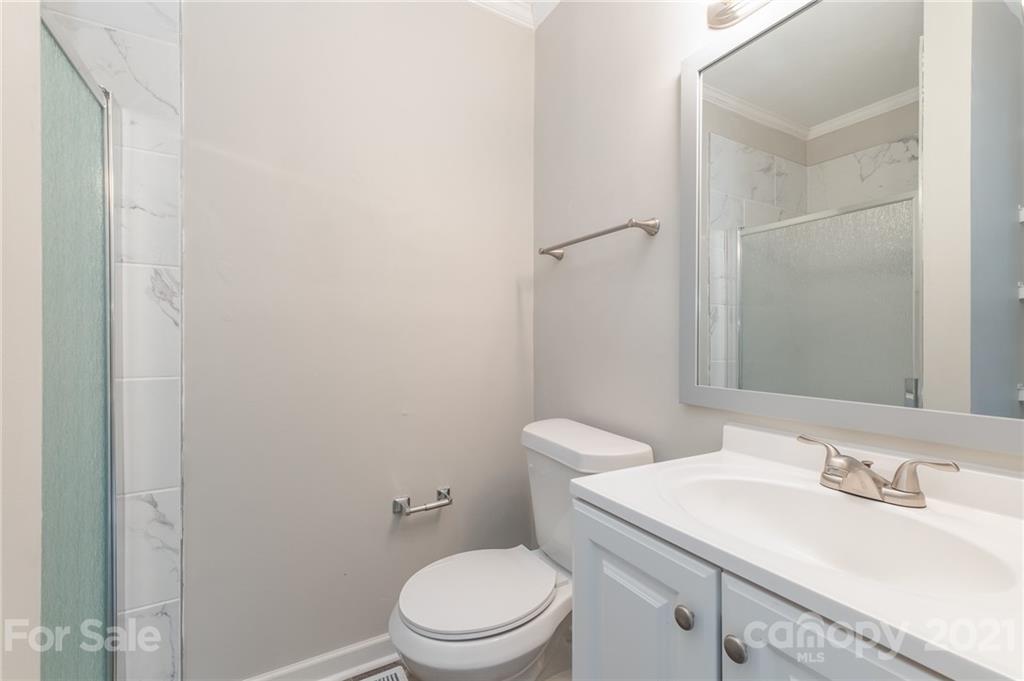 113 Hillside Avenue Southwest Concord, NC 28025 - Photo 11 of 19 a bathroom with a sink a toilet and a mirror