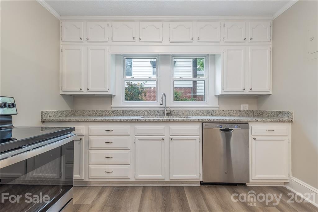 113 Hillside Avenue Southwest Concord, NC 28025 - Photo 8 of 19 a kitchen with granite countertop white cabinets and white appliances