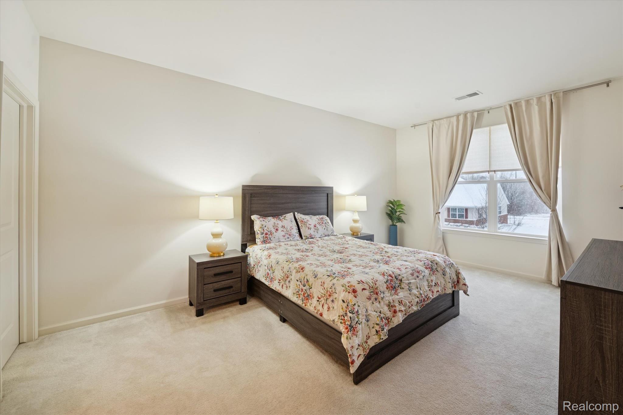 10028 Ridge Run Street, Unit 10 Howell, MI 48855 - Photo 11 of 21 Primary bedroom with large window and ample space.