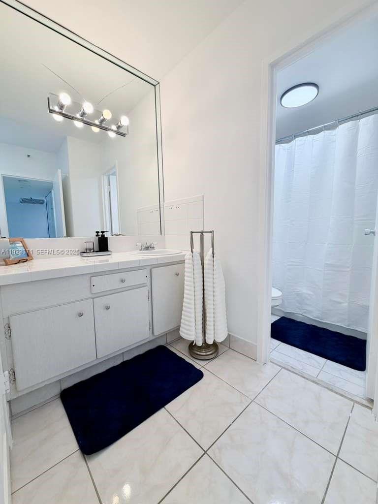 100 Lincoln Road, Unit 541 Miami Beach, FL 33139 - Photo 13 of 17 a spacious bathroom with a double vanity sink a mirror and a bathtub