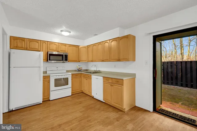 a kitchen with white cabinets and white appliances