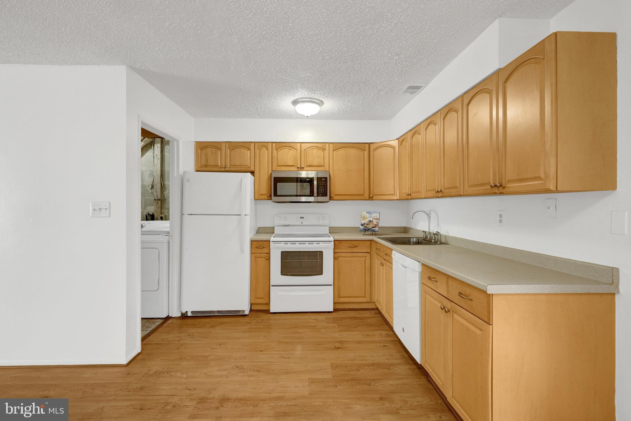 2142 Cartwright Place Reston, VA 20191 - Photo 12 of 46 a kitchen with stainless steel appliances granite countertop a stove and a refrigerator