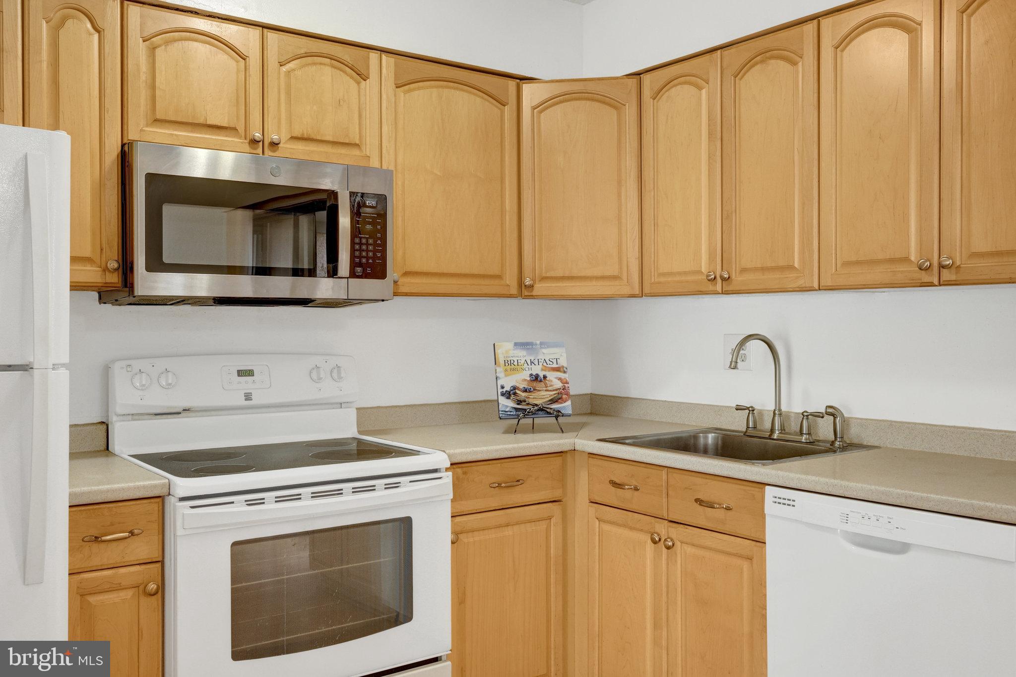 2142 Cartwright Place Reston, VA 20191 - Photo 15 of 46 a kitchen with stainless steel appliances granite countertop white cabinets a microwave a sink and a counter space