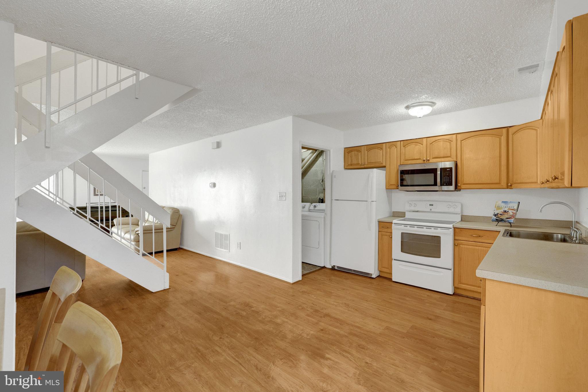 2142 Cartwright Place Reston, VA 20191 - Photo 16 of 46 a kitchen with cabinets and wooden floor