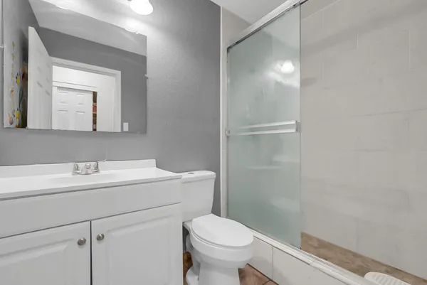 a bathroom with a toilet sink vanity and mirror