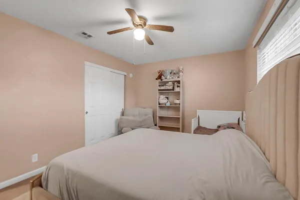 a bedroom with a bed and a ceiling fan