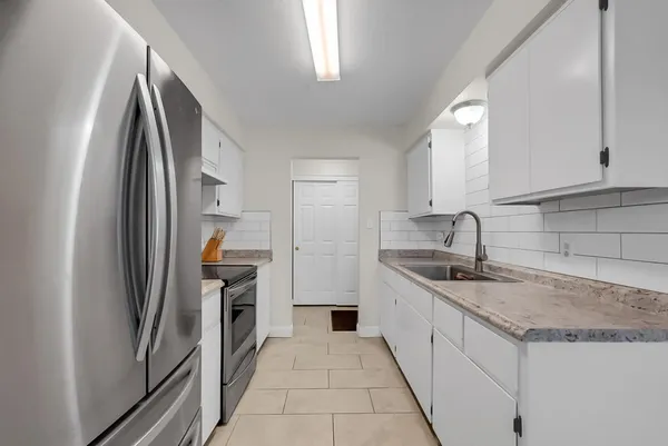 a kitchen with stainless steel appliances granite countertop a refrigerator and a sink