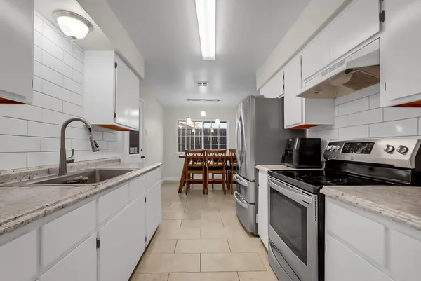 a kitchen with stainless steel appliances a sink stove and cabinets
