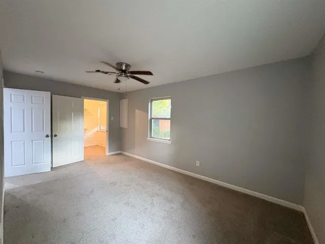 an empty room with wooden floor fireplace and windows