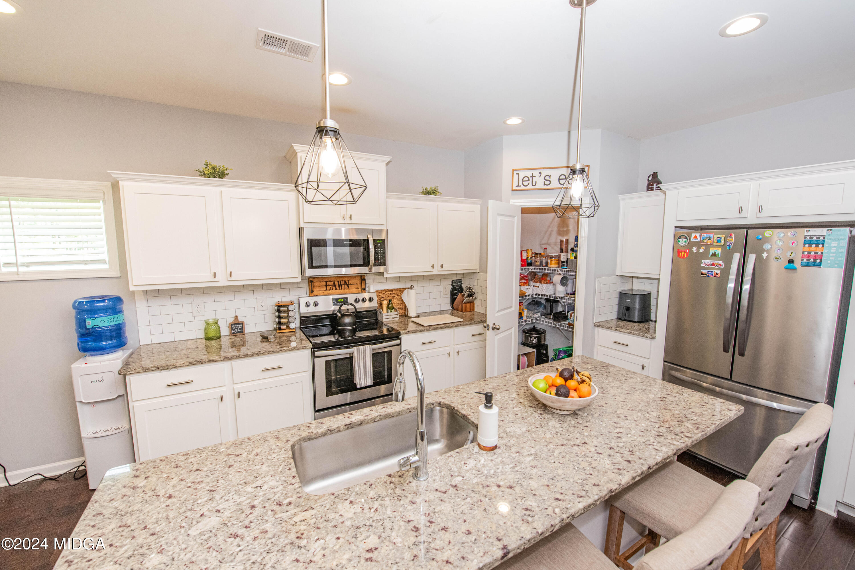 103 Wax Myrtle Way Perry, GA 31069 - Photo 18 of 62 a kitchen with stainless steel appliances granite countertop a sink dishwasher a stove a dining table and chairs with wooden floor