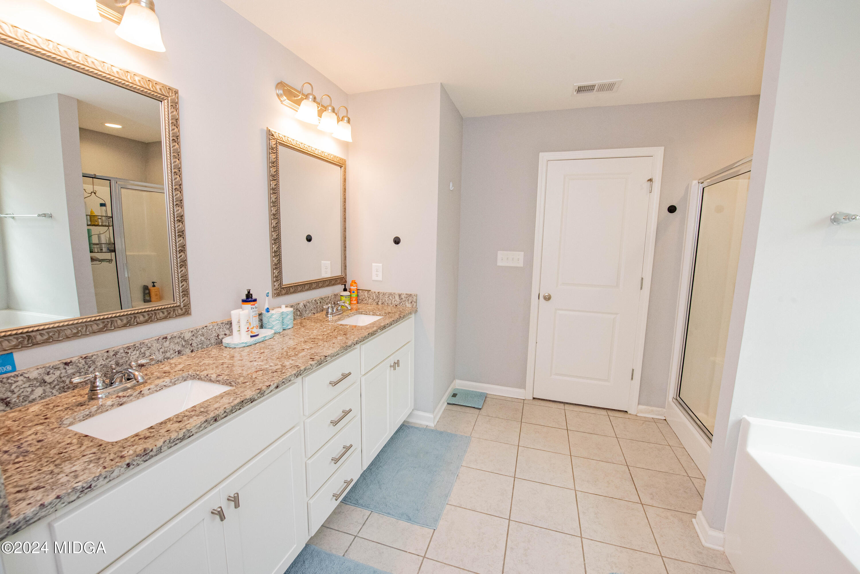 103 Wax Myrtle Way Perry, GA 31069 - Photo 43 of 62 a spacious bathroom with a granite countertop sink and a mirror