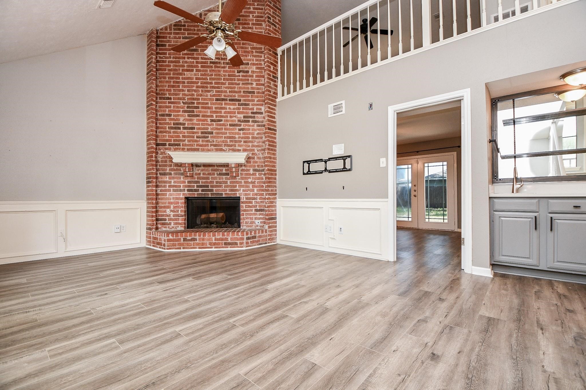 2331 Wren Meadow Road Richmond, TX 77406 - Photo 4 of 37 Your spacious main living space features very high ceilings and floor to ceiling brick fireplace! Also complimented by classic wainscoting, open view from the 2nd floor gameroom and a wet bar for entertaining!