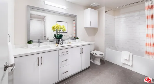 a bathroom with a granite countertop toilet sink and mirror