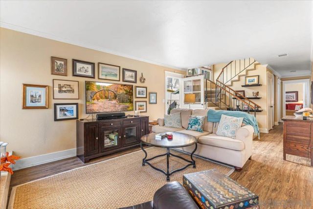 a living room with furniture a rug and a painting on the wall