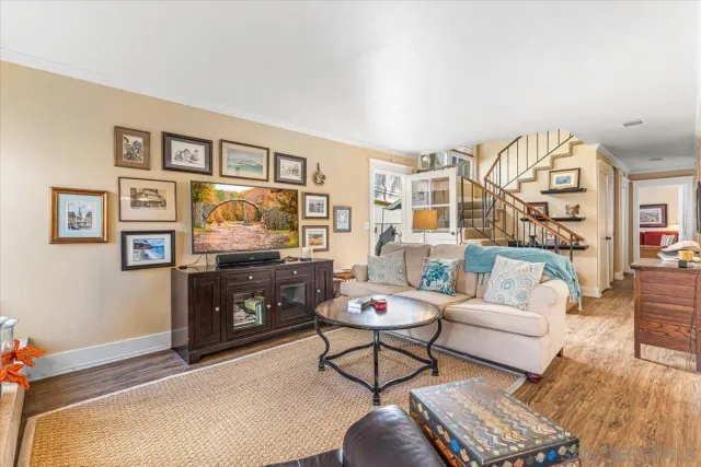 a living room with furniture a rug and a painting on the wall