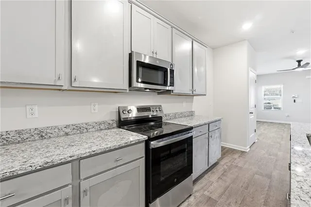 a kitchen with granite countertop wooden cabinets and a stove top oven