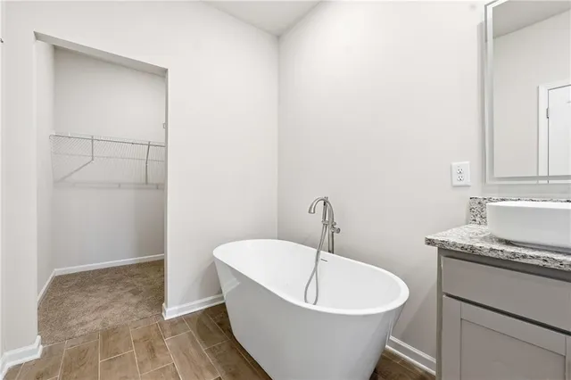 a bathroom with a tub a sink and mirror